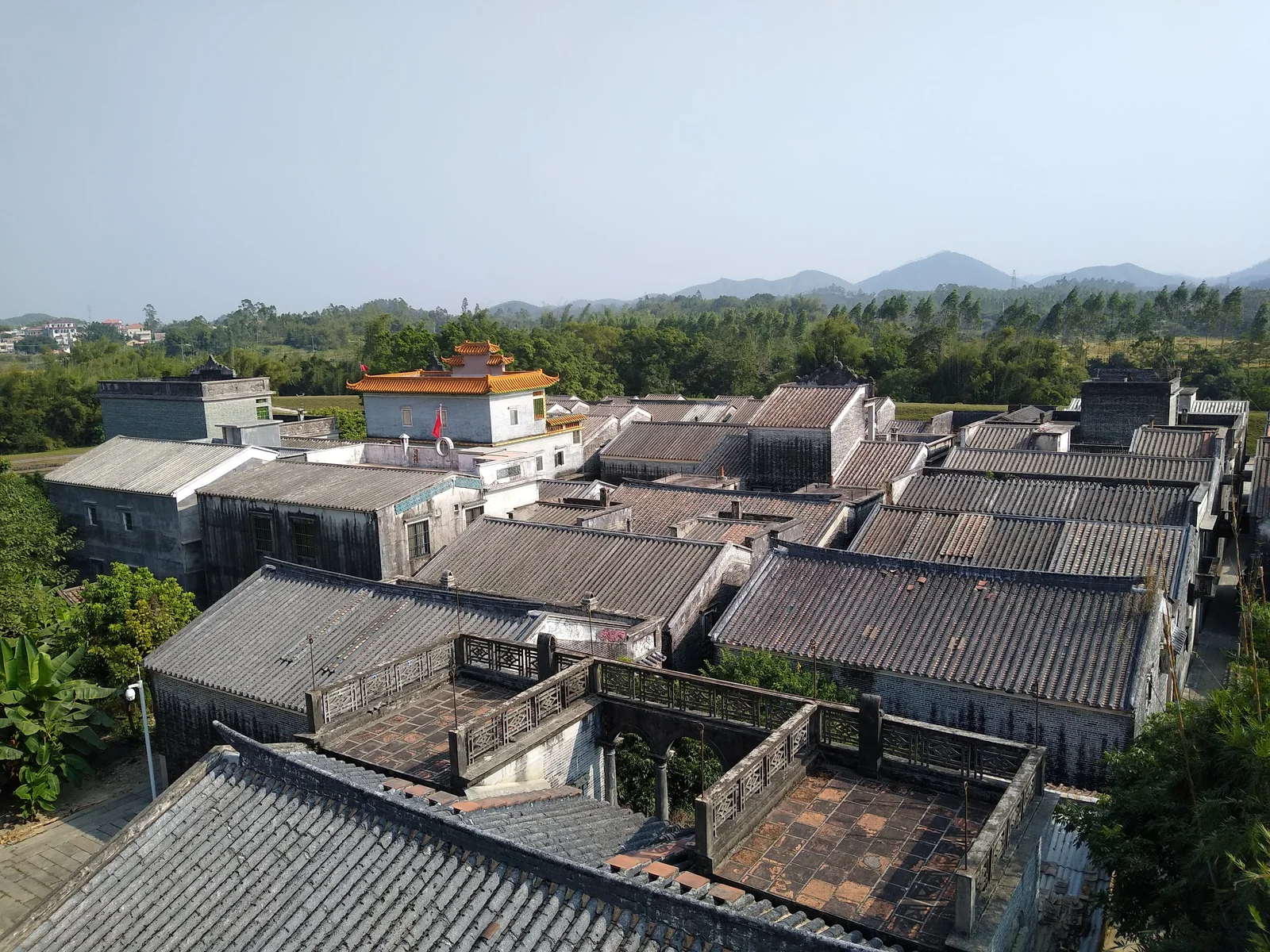 Tiled village rooftops and green countryside in Jinjiangli, Kaiping