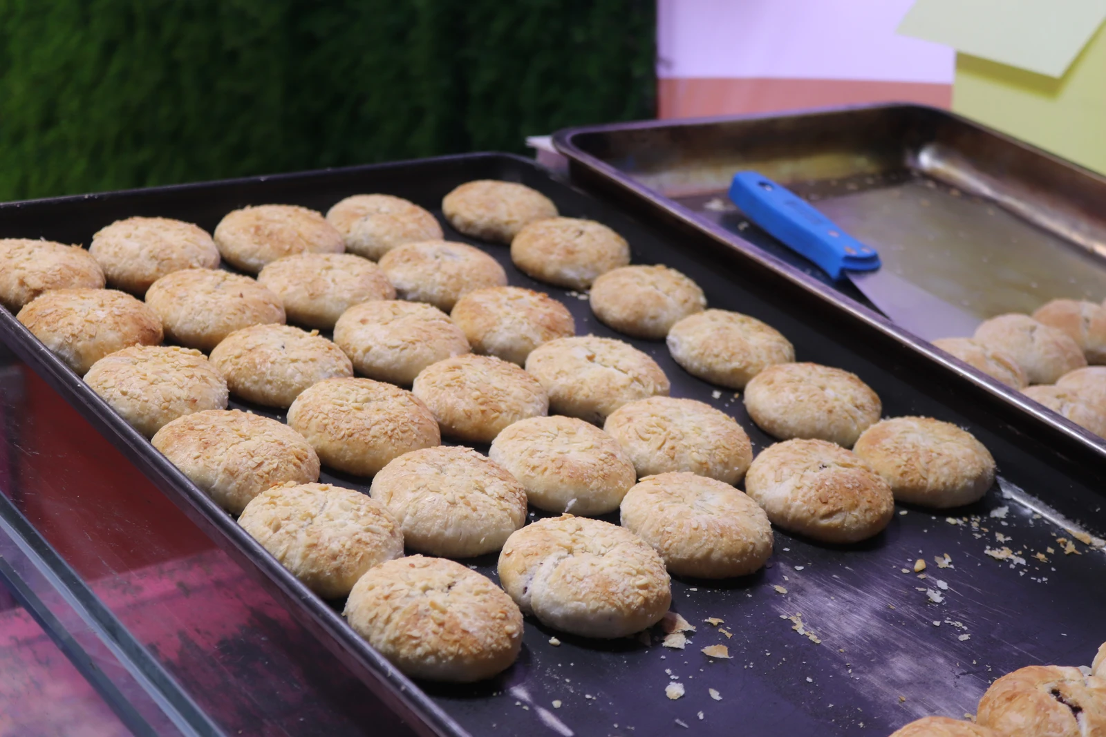 Freshly baked Yunnan rose pastries laid out on a market griddle