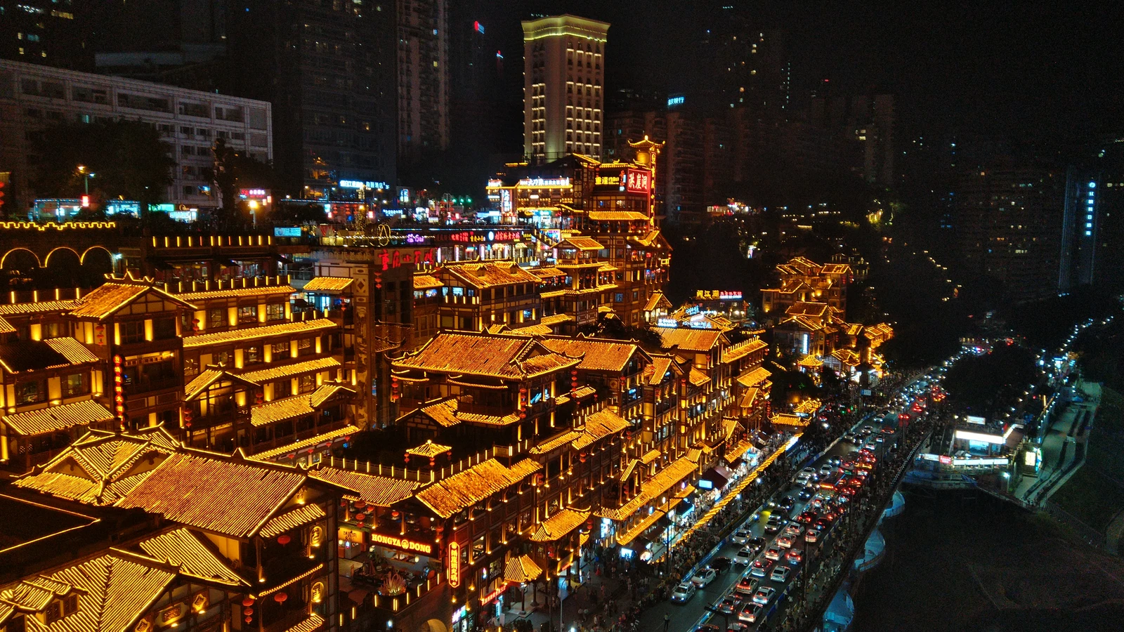 The illuminated Hongya Cave complex overlooking the river in Chongqing at night