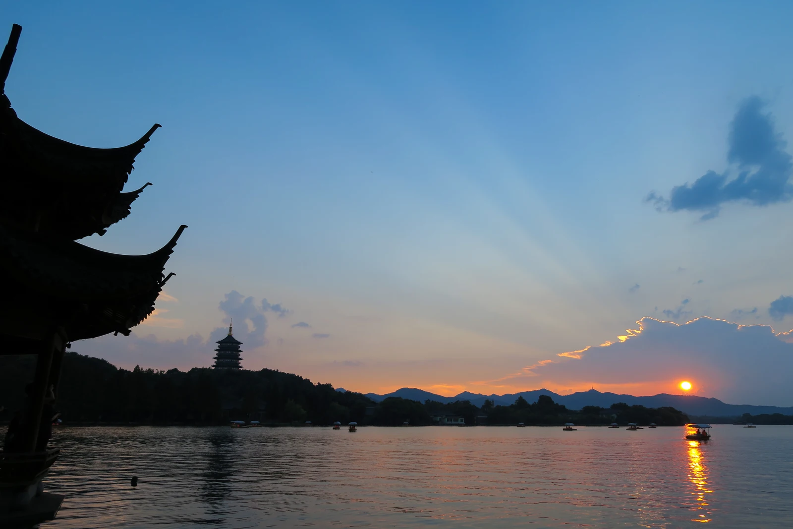 Leifeng Pagoda silhouetted across West Lake at sunset